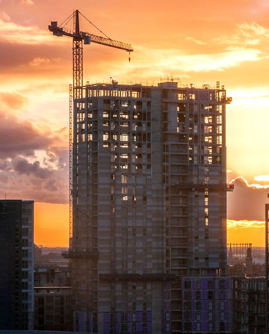 Residential tower under construction at sunset